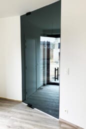 Pivoterende glazen deur met grijs glas